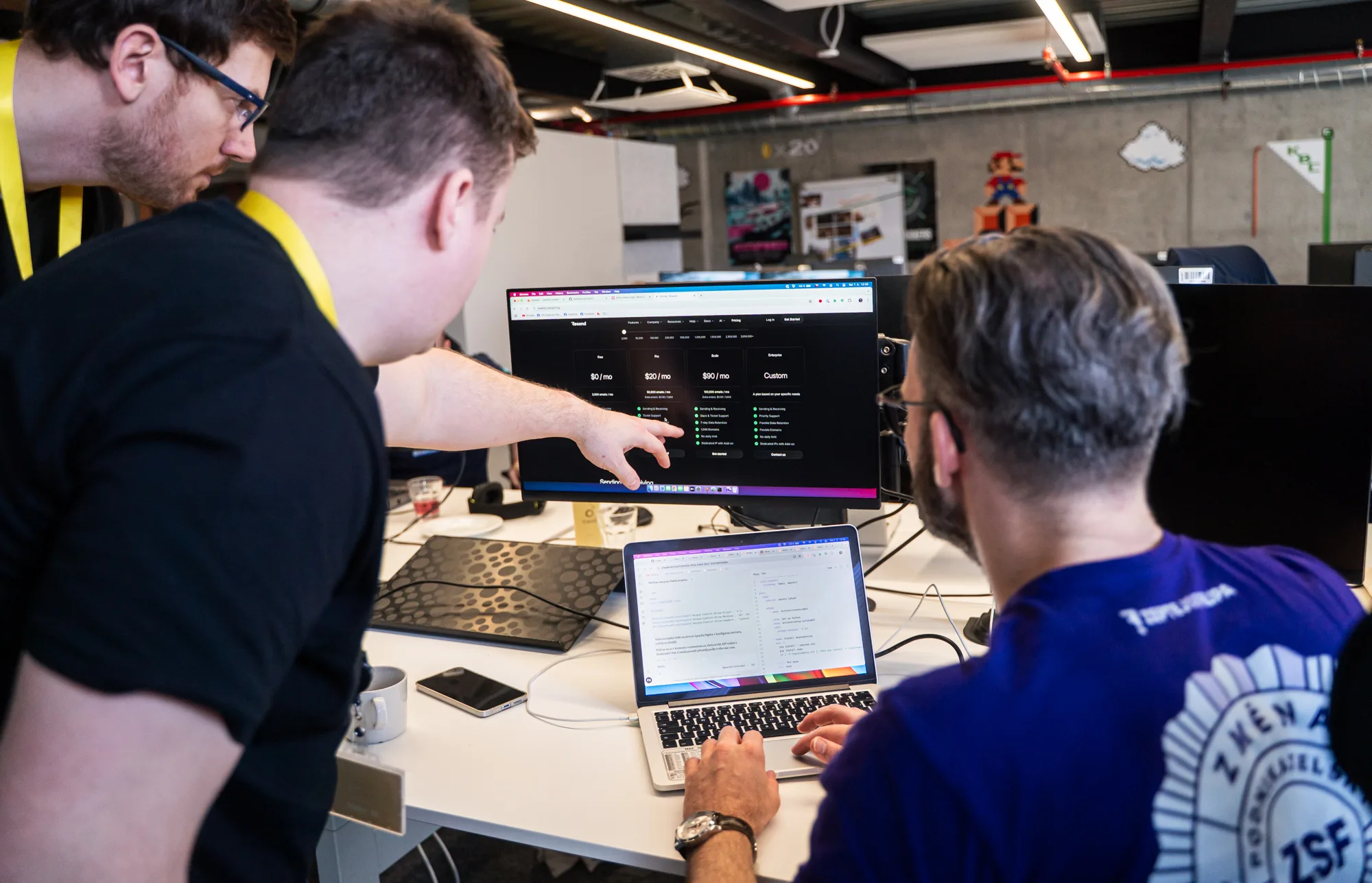 Traja ľudia pri počítači na hackathone ČSOB, na monitore cenník e-mailovej služby
